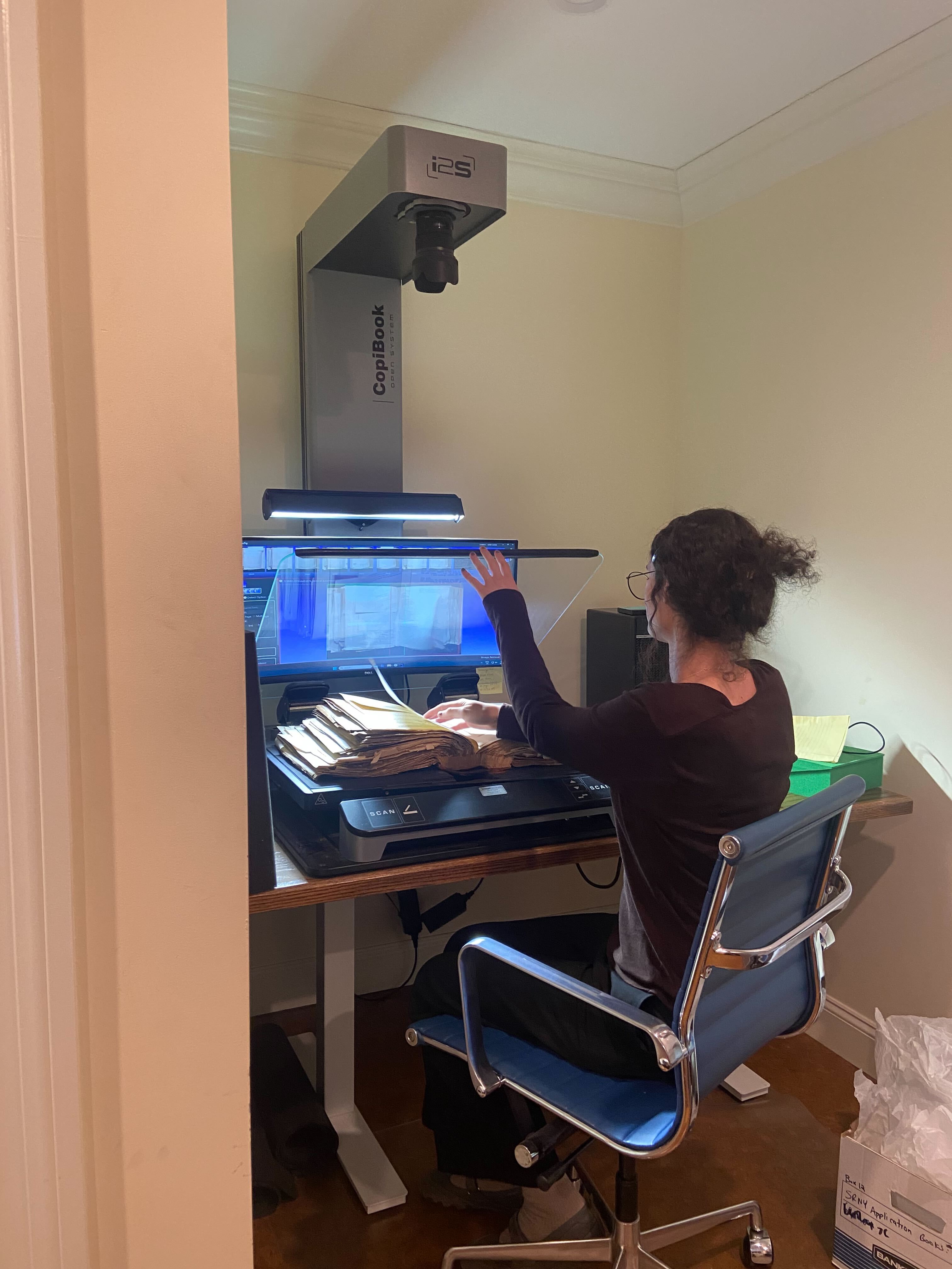Shane Minster, Digitization Operator, scans an oversized volume at the New York City Digitization Center.