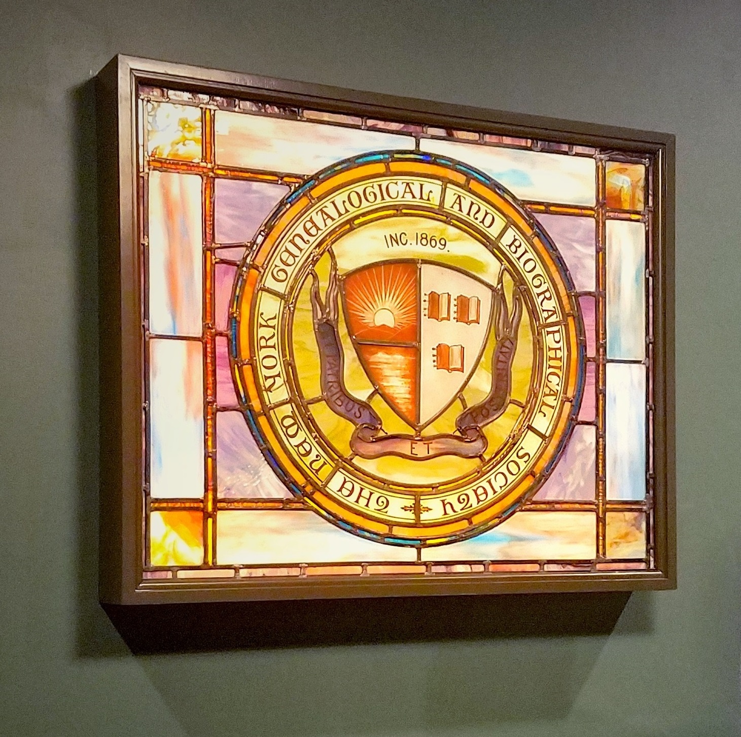 A stained glass window displaying the seal of the New York Genealogical and Biographical Society
