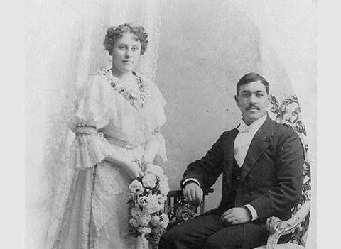 Wedding picture, man seated and woman holding flowers and standing, c 1894